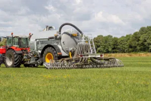 Slootsmid bemester met mesttank en tractor aan het werk op grasland